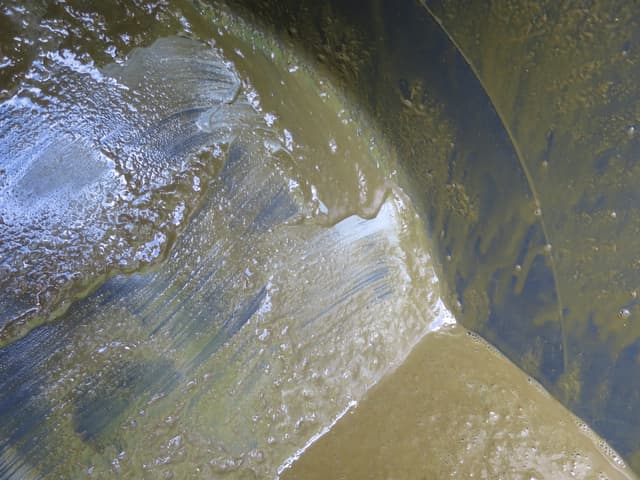 Aufgerührte Gülle in einer Grube, an der Oberfläche verwirbelt